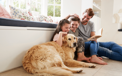 Happy family relaxing with their golden retriever at home.